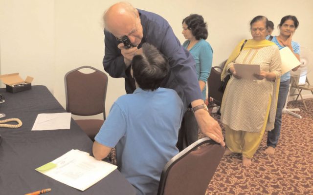 Eye check up of a patient while others wait for their turn