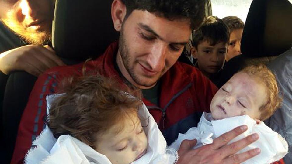 In this picture taken on Tuesday April 4, 2017, Abdel Hameed Alyousef holds his twin babies who were killed during a suspected chemical weapons attack